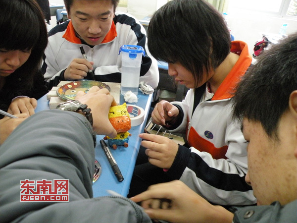 同學(xué)們?cè)诶蠋煹闹笇?dǎo)下制作心愿卡作品。